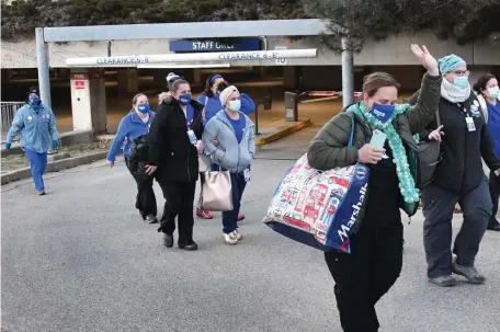  ?? CHRIS CHRISTO PHOTOS / HERALD STAFF ?? WALKING OUT: Saint Vincent Hospital nurses leave the hospital and go out on strike just after 6 a.m. on Monday. Below, nurses and supporters arrive before the strike carrying signs referencin­g CEO Carolyn Jackson.