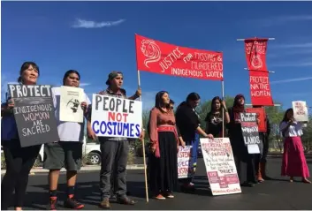  ??  ?? Native American protesters stand outside the Phoenix office retailer of “sexy Native American” costumes on Wednesday. AP PhOtO/terry tAng