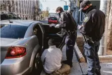  ?? Nick Otto / Special to The Chronicle 2020 ?? Officers Kerry Mullins (left) and Cullen Roche talk to people caught with narcotics in the Tenderloin in December 2020.