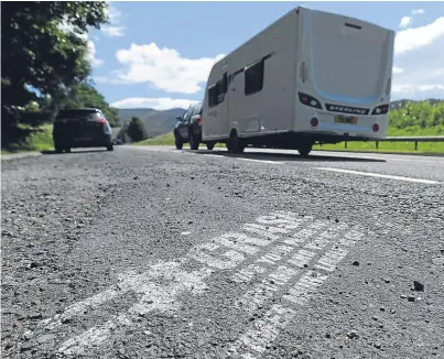  ??  ?? One of the slogans created on the road surface in lay-bys along the A9.