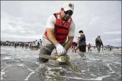  ?? COURTNEY SACCO / CORPUS CHRISTI CALLER-TIMES ?? Padre Island National Seashore volunteer Jose Untalan releases a rehabilita­ted cold stunned-sea turtle into the Gulf on Sunday.