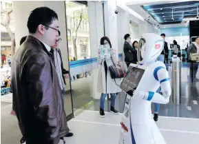  ?? Photo: Xinhua ?? A customer talks with a robot at the entrance of a self-service area of Jiujiang Road branch of China Constructi­on Bank (CCB) in Shanghai, east China, April 12, 2018.