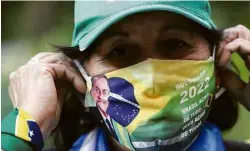  ?? Amanda Perobelli/Reuters ?? Apoiadora de Jair Bolsonaro em frente ao hospital onde ele está internado, em São Paulo