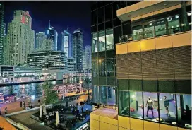  ?? [AP FILE PHOTO] ?? In this March 25, 2015, photo, men work out in a gym along the Marina waterfront in Dubai, United Arab Emirates.