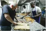  ?? ?? Employees cook “Crookies”, a traditiona­l French croissant mixed with cookie dough, in the pastry shop of French pastry chef Stephane Louvard in Paris.