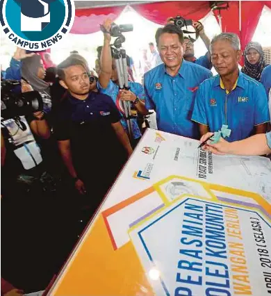  ?? PIC BY AMRAN HAMID ?? Idris Jusoh signing a plaque at the launch of Kolej Komuniti in Jerlun witnessed by Deputy Finance Minister 1, Jerlun Member of Parliament Datuk Seri Othman Aziz (third from right).