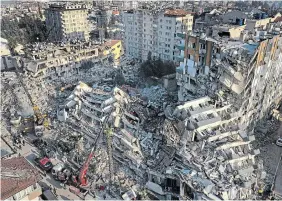  ?? ?? Rescue teams search for people as cranes remove debris from destroyed buildings in Antakya, southeaste­rn Turkey, on Friday. Rescuers pulled more than a dozen survivors from the shattered remnants of buildings Friday, including some who lasted more than 100 hours trapped under crushed concrete after the disaster slammed Turkey and Syria.