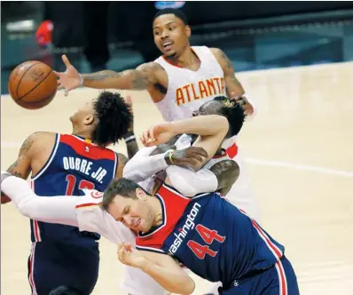  ?? JOHN BAZEMORE / AP ?? Washington Wizards guard Bojan Bogdanovic (44) and Atlanta Hawks guard Dennis Schroder collide as Kent Bazemore and Kelly Oubre Jr. vie for the ball during Game 3 of their NBA first-round playoff series in Atlanta on Saturday. The Hawks cruised to a...