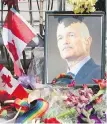  ?? RYAN REMIORZ, CP ?? A portrait of the late NDP leader Jack Layton sits in flowers at a temporary memorial outside Toronto City Hall on Aug. 26, 2011.