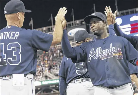  ?? JIM MONE / AP ?? The Braves’ Adonis Garcia (right), getting a high-five from manager Brian Snitker after beating the Twins on Tuesday, has become a better player since being sent down to Triple-A Gwinnett (where his manager was Snitker).