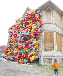  ??  ?? Jake England, 23 months old, checks out a Beakerhead installati­on called Dreams Never Die on 11th Avenue S.E. on Wednesday. The installati­on is designed by artist Maria Galura and was inspired by the movie Up.