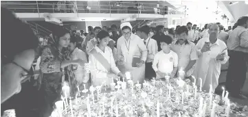  ?? — AFP photo ?? Students and people light candles to pay respects to the victims of Sri Lanka’s serial bomb blasts, during a mass prayer at the Fatima Church in Islamabad, Pakistan.