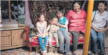  ??  ?? SEDENTARY LIFE: A family resting in a yurt on the outskirts of Ulan Bator. Many suburban slum dwellers gave up the traditiona­l lifestyle of Mongolia’s herder population to move to the capital.