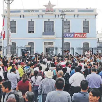  ??  ?? Partidario­s de Alan García fuera de la sede del APRA ayer, en Lima.