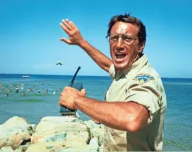  ?? UNIVERSAL PICTURES ?? Roy Scheider tries to get people out of the water in a scene from the 1975 film “Jaws.” With major new releases postponed until at least Labor Day weekend due to the pandemic, summer moviegoing has belonged to the classics.