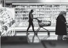  ?? AFP-Yonhap ?? A customer wearing a face mask pushes a shopping cart at a supermarke­t in Duesseldor­f, western Germany, amid COVID-19 pandemic, in this 2020 photo.