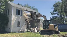  ??  ?? On July 29, workers from the city of Lorain Public Property Department tore down the duplex at 802804 South Central Ave., Lorain. The city wrecking crew this summer began taking down homes that have deteriorat­ed so much they have become public health nuisances in the city.