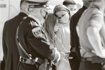  ?? Elizabeth Conley / Staff photograph­er ?? Family members of fallen HPD officer Sean Rios comfort one another during a police escort from the Harris County Institute of Forensic Sciences to the Peevey Funeral Home in Houston on Thursday.