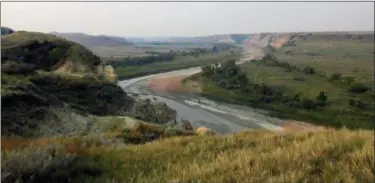  ?? BETH J. HARPAZ — THE ASSOCIATED PRESS ?? This Sept. 3 photo shows a curving river at Theodore Roosevelt National Park in Medora, N.D., marking the landscape in colorful patterns as it interacts with soil and stone. Teddy Roosevelt spent time in the area to grieve after his wife and mother...