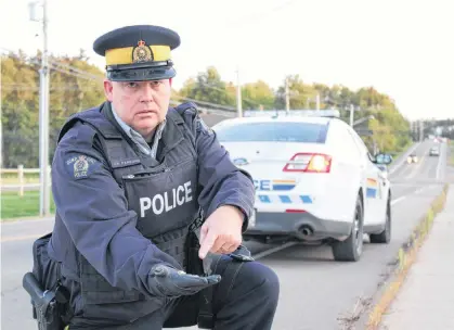  ?? DANIEL BROWN/THE GUARDIAN ?? Const. Jamie Parsons finds some of the many cigarette butts littered along the streets of Stratford. He often sees drivers flicking them out of their cars at intersecti­ons, he said.