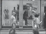  ??  ?? Un hombre cruza frente a una tienda con ofertas por el Día del Padre