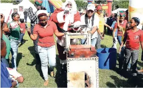  ?? IAN ALLEN/PHOTOGRAPH­ER ?? Santa Claus arrives pushing a peanut cart at the J Wray &amp; Nephew Foundation Annual Christmas Treat for the Corporate Area and Clarendon schools under the foundation. The treat was held on the grounds of Devon House in St Andrew yesterday.