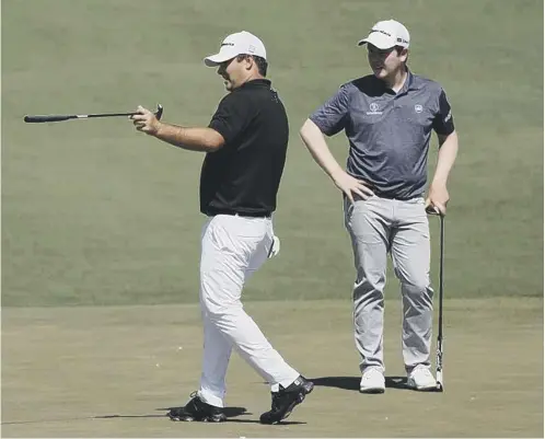  ??  ?? 0 Patrick Reed, the 2018 winner, offers some advice to Bob Macintyre, right, during a Masters practice round earlier this week