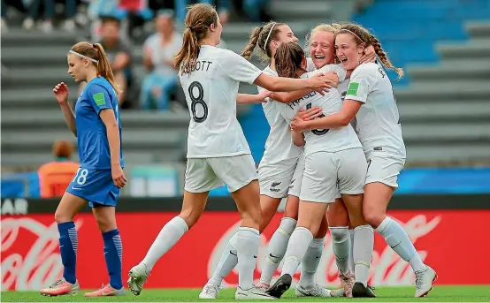  ??  ?? Kelli Brown is swamped by team-mates after scoring a spectacula­r goal in New Zealand’s opening game of the Under-17 Women’s World Cup.