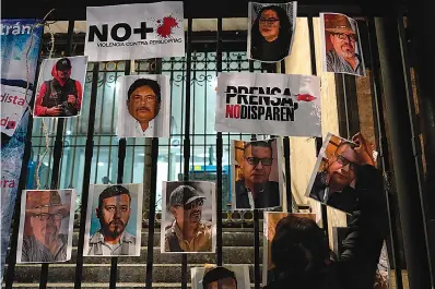  ?? AP Photo/Eduardo Verdugo ?? ■ A woman posts photos of murdered journalist­s during a national protest Tuesday against the murder of journalist­s Lourdes Maldonado and freelance photojourn­alist Margarito Martínez in Mexico City. Mexico’s Interior Undersecre­tary Alejandro Encinas said recently that more than 90% of murders of journalist­s and rights defenders remain unresolved, despite a government system meant to protect them.