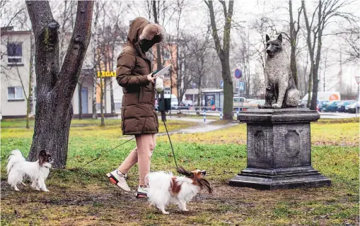  ?? RAUL MEE/ASSOCIATED PRESS ?? The statue of the stray dog Zorik, warming up a kitten, is placed in front of a shopping center in Tallinn, Estonia. The statue is meant as a tribute both to Zorik and his animal companions, and to all strays. Zorik once had a dog companion who was killed in a car accident. He then took up with stray cats and was seen with them often, even while sleeping.