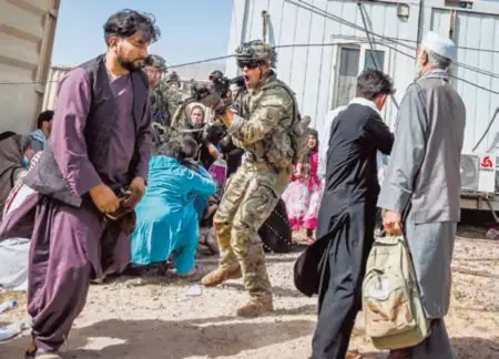  ?? AFP ?? Un soldado de EU apunta contra afganos que intentan entrar al aeropuerto internacio­nal de Kabul