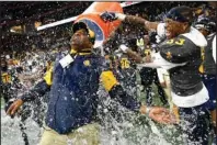  ?? The Associated Press ?? TRYING TO RETURN: North Carolina A&T coach Sam Washington is doused by defensive back Jalon Bethea during the final seconds of the Celebratio­n Bowl on Dec. 21, 2019, against Alcorn State, in Atlanta. Teams in the SWAC as well as many other HBCUs across the country play in the Football Championsh­ip Subdivisio­n. Schools at this level earn some money from television contracts, but nothing like the multimilli­on-dollar deals for the Power Five. In the SWAC, the main source of revenue from football comes from putting fans in the stands and there are no substitute­s for that at schools that often have limited resources.