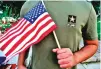  ?? ASSOCIATED PRESS FILE PHOTO ?? A Pakistani recruit, 22, who was recently discharged from the U.S. Army, holds an American flag July 3. A Wednesday memo spells out orders to stop processing discharges of men and women who enlisted in the special immigrant program, effective immediatel­y.
