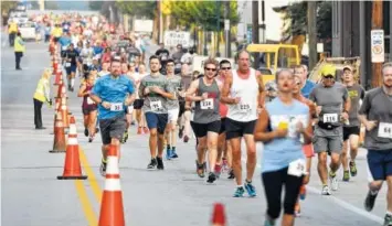  ?? STAFF FILE PHOTO ?? Runners head east on Main Street at a previous Run of Honor. The 8K race will be held Sunday morning to raise money for the Sgt. Tim Chapin Scholarshi­p Fund and the Fort Campbell Fisher House.