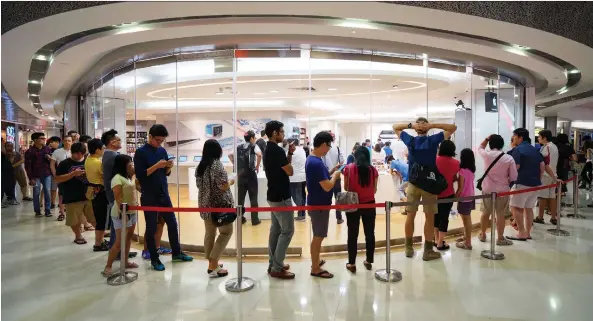  ?? BRYAN VAN DER BEEK /BLOOMBERG ?? Customers wait in line to look at Apple Watch devices on display at a Singapore mall. Singapore is boldly testing new waters with its launch of a five-year plan this year to streamline its infrastruc­ture and reduce bureaucrac­y with cutting-edge technology. At the same time, the city-state’s government insists it takes data privacy seriously.