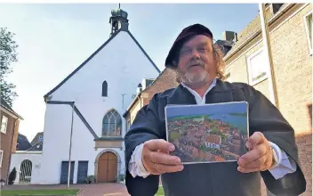  ?? RP-FOTOS (2): MICHAEL SCHOLTEN ?? Mesner Heinz Welmann zeigte anhand einer Luftbildbi­ldaufnahme von Wahid Valiei wie die evangelisc­he Kirche 1624 in den Höfen gebaut wurde.