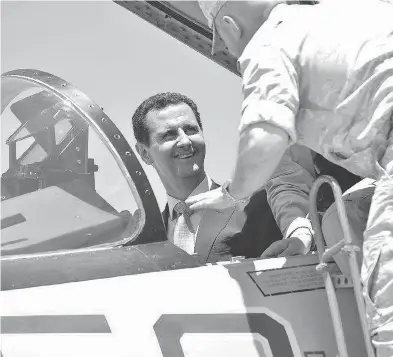  ?? SYRIAN PRESIDENCY FACEBOOK PAGE / AFP / GETTY IMAGES ?? Syrian President Bashar al-Assad sits inside a Sukhoi Su-27 jet during a recent visit to the Russian-run Hmeimim military base. The White House warned Syria against further use of chemical weapons.