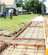  ?? Photo by Neil Abeles ?? Assistant City Manager Allie Anderson and City Manager Lee Elliott are standing away from the new sidewalk but closer to the Wright Patman home on North Main in Linden.