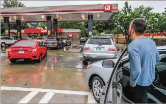  ?? JOHN SPINK/JOHN.SPINK@AJC.COM ?? Mirweis Jalalzai, who moved here from Afghanista­n five years ago, waits in line at a Dekalb County Quiktrip station. He said he never saw his former country’s gas stations run out. Lines formed Wednesday morning at the Quiktrip at Briarcliff Road and North Druid Hills as gas continued to flow at the station there until noon before running out.