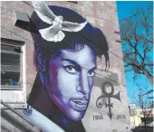  ?? AP PHOTO/JEFF BAENEN ?? In this photo taken on Monday, a painting of the late Prince is shown on a Minneapoli­s building.