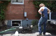  ?? MARIAN DENNIS — MEDIANEWS GROUP ?? Residents of Lumber Street in Green Lane worked most of the day Friday to pump about 6-8 inches of water out of their basements after Thursday’s storm.