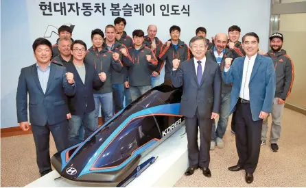  ?? Courtesy of Hyundai Motor ?? Hyundai Motor Vice Chairman Yang Woong-chul, second from right in the front row, poses with Korea’s national bobsleigh team officials during a sleigh delivery ceremony at the firm’s research center in Hwaseong, Gyeonggi Province, Oct. 21 last year.