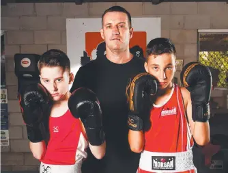  ??  ?? Lindgren Boxing juniors Sonny Lindgren, 11, and Sonny Prasser, 13, with their coach Johnny Lindgren ahead of their fight tomorrow night. Picture: ALIX SWEENEY
