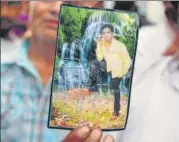  ?? SONU MEHTA/HT PHOTO ?? Shahrukh’s father Istikar holds up an old photo of his son. He is survived by a wife and an infant son.