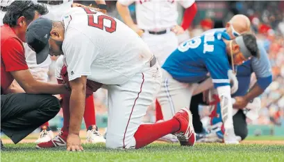  ?? WINSLOW TOWNSON/THE ASSOCIATED PRESS ?? Red Sox starter Eduardo Rodriguez and Jays baserunner Lourdes Gurriel Jr. get attention after colliding af first base in the sixth.