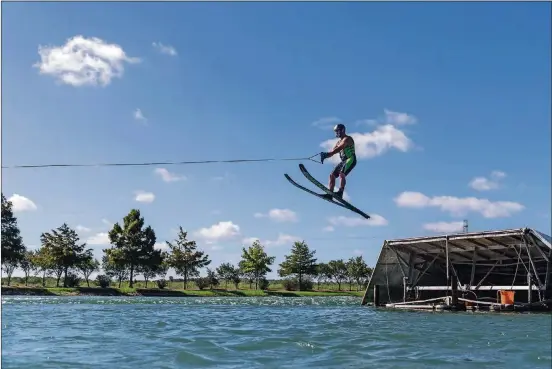  ?? AMERICAN-STATESMAN PHOTOS TAMIR KALIFA/ ?? Jimmy Siemers, ski jumping instructor and former world champion, jumps off a ramp at the Aquaplex ski lake in Martindale. This is how it’s supposed to be done.