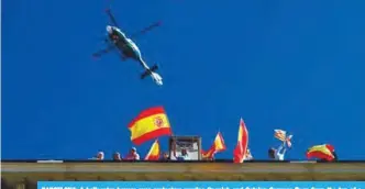  ?? AFP ?? BARCELONA: A helicopter hovers over protesters waving Spanish and Catalan Senyera flags from the top of a building during a pro-unity demonstrat­ion yesterday. —