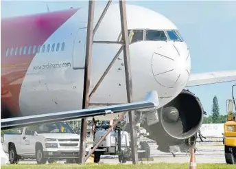  ?? TAIMY ALVAREZ/STAFF FILE PHOTO ?? The fire-damaged jetliner remains idled in the northwest corner of the airport.