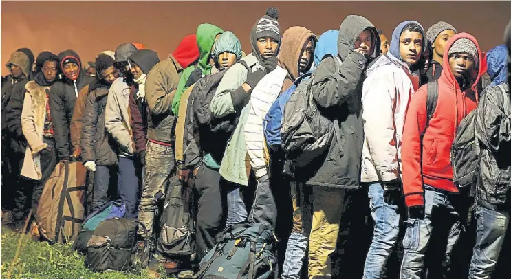  ?? REUTERS ?? Espera. Larga fila de inmigrante­s en Calais, a la espera de subir a alguno de los ómnibus que los llevará al interior. Son al menos 7.300 refugiados que será relocaliza­dos.