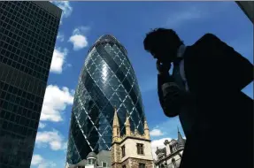  ?? REUTERS ?? A man passes the Swiss Re building in the City of London financial district.